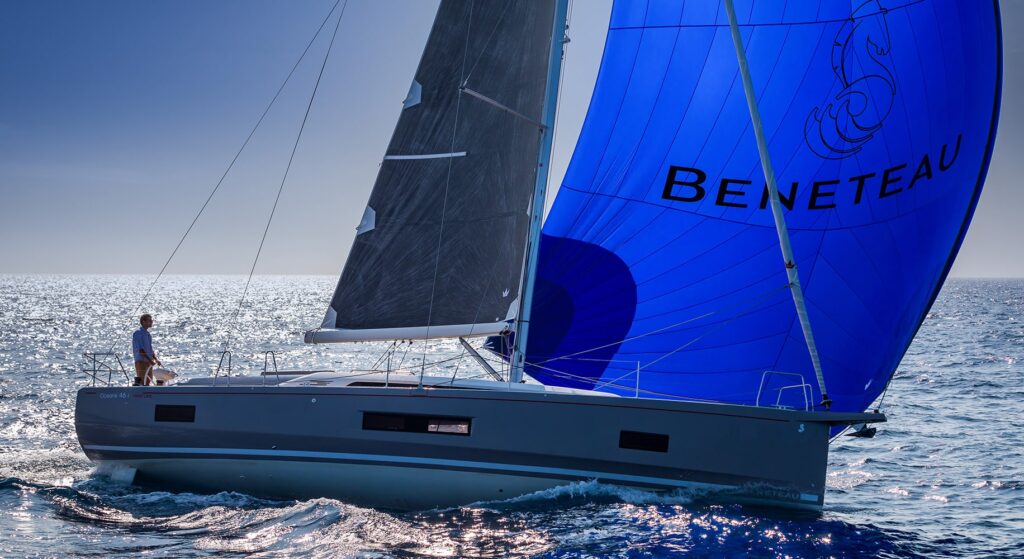 Ein Segelboot mit einem auffälligen blauen Spinnaker mit der Aufschrift